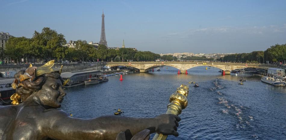 atletas saltan y nadan en el río Sena cerca del puente Alexander III