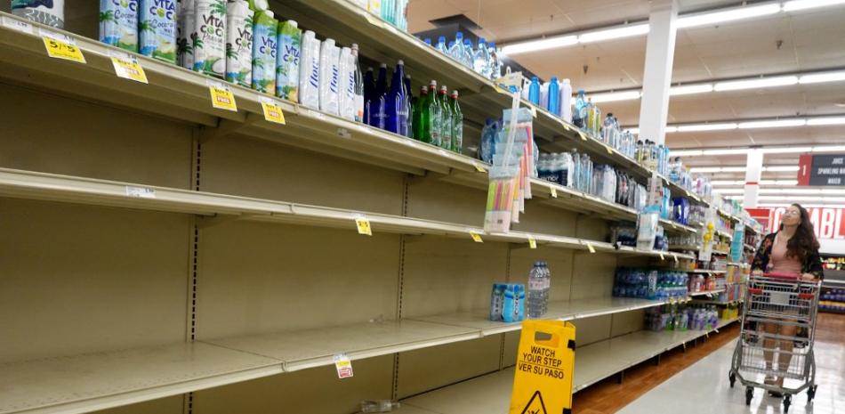 La sección de agua de una tienda de comestibles está casi vacía mientras la gente se abastece antes de la posible llegada del huracán Idalia