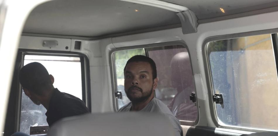 Sospechoso colombiano no identificado, sentado en una camioneta esposado, quien comparecerá ante un juez por el asesinato de Jovenel Moise.