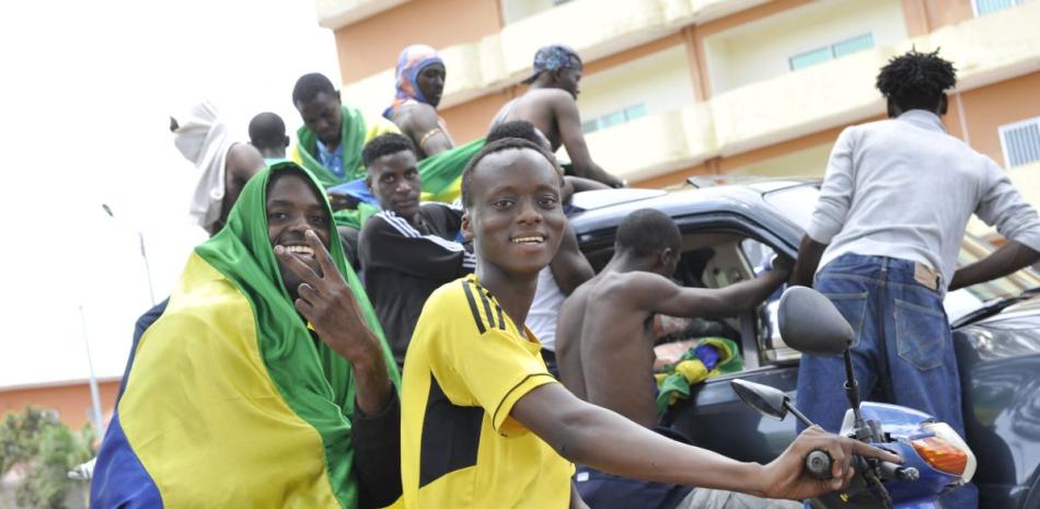 Un hombre con una bandera nacional de Gabón sobre sus hombros hace un gesto mientras celebran en Libreville ayer el golpe militar.