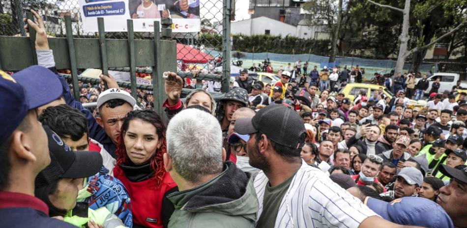 Migrantes venezolanos hacen cola mientras esperan recibir el Permiso Especial de Permanencia (
