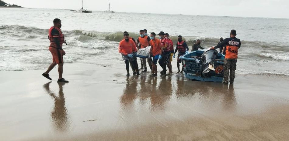 Momento en que las autoridades sacan el cuerpo de la playa