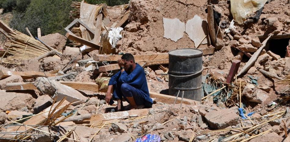 Un hombre llora sentado sobre los escombros de una casa en la aldea de Tikht