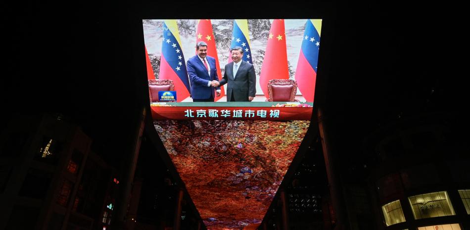 Una pantalla gigante frente a un centro comercial muestra la cobertura noticiosa de la reunión del presidente venezolano, Nicolás Maduro, con el presidente chino, Xi Jinping, en Beijing el 13 de septiembre de 2023.