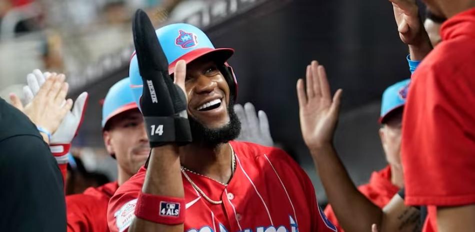 Brian De la Cruz celebra con varios compañeros al llegar al dugout luego de anotar una de las carreras de los Marlins.