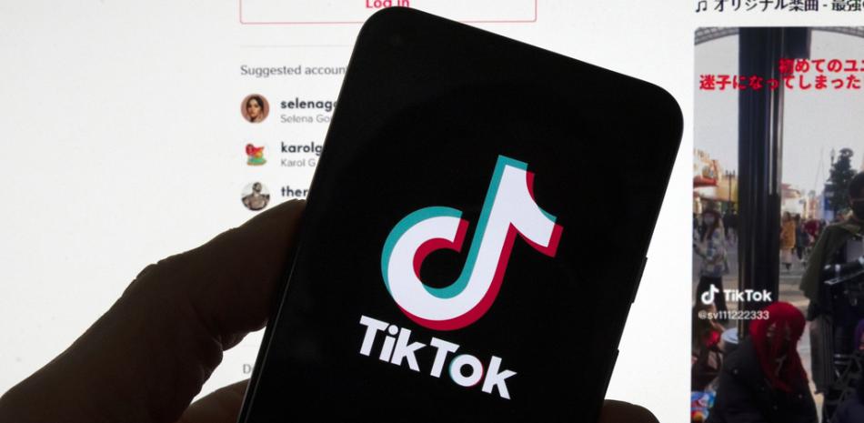 El logotipo de TikTok se ve en un teléfono móvil frente a una pantalla de computadora que muestra la pantalla de inicio de TikTok, el sábado 18 de marzo de 2023, en Boston.