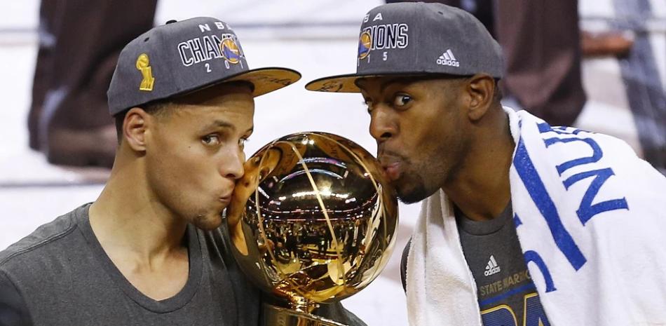 Stephen Curry y Andre Iguodala besan el trofeo de campeón obtenido en el 2015.