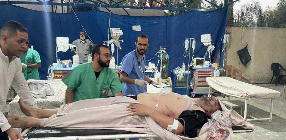 Cirujanos de traumatología transportan en una camilla a un herido que llega tras un bombardeo israelí, en el hospital kuwaití de Rafah, en el sur de la Franja de Gaza en medio de los continuos combates entre Israel y Hamás