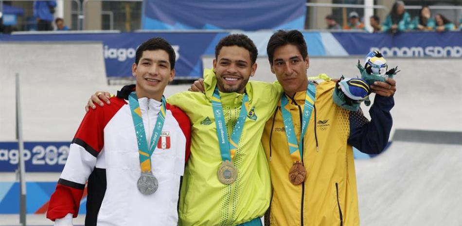 Lucas Rabelo Nobre (c) de Brasil, medalla de oro, Angelo Caro (i) de Perú, medalla de plata, y Luis González de Colombia, bronce, posan en el podio de skateboarding street hoy, de durante los Juegos Panamericanos 2023 en Santiago (Chile).