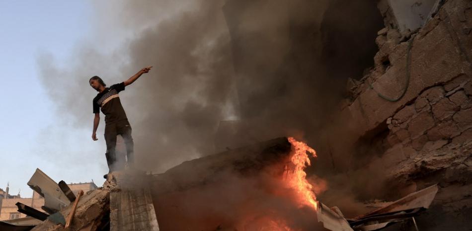 Un palestino gesticula sobre los escombros de un edificio derrumbado mientras arde un incendio tras un ataque del ejército israelí contra Jan Yunis, en el sur de la Franja de Gaza, el 4 de noviembre de 2023, en medio de las continuas batallas entre Israel y el grupo palestino Hamás.