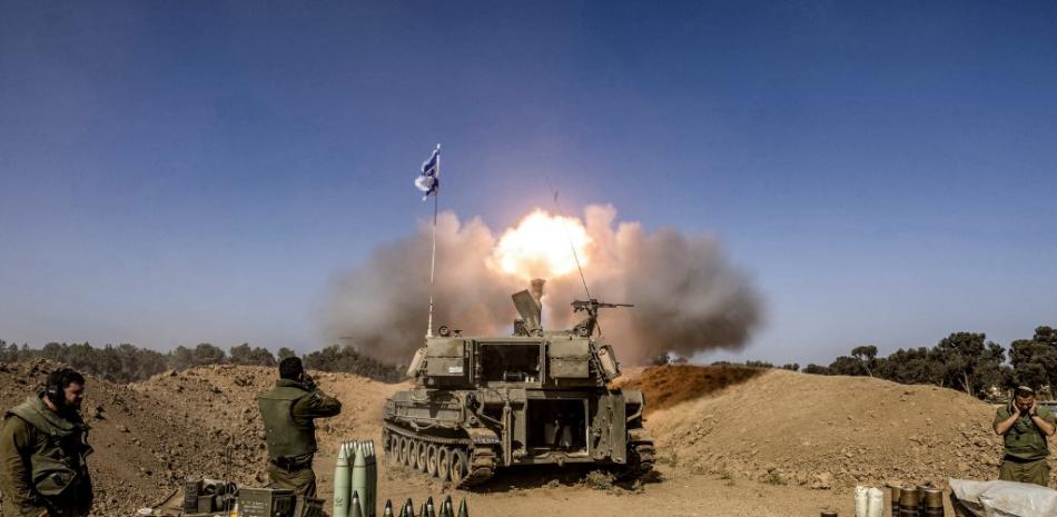 Soldados del ejército israelí se tapan los oídos mientras un obús de artillería autopropulsado dispara desde una posición cerca de la frontera con la Franja de Gaza en el sur de Israel el 6 de noviembre de 2023 en medio de las batallas en curso entre Israel y el grupo palestino Hamás en la Franja de Gaza.