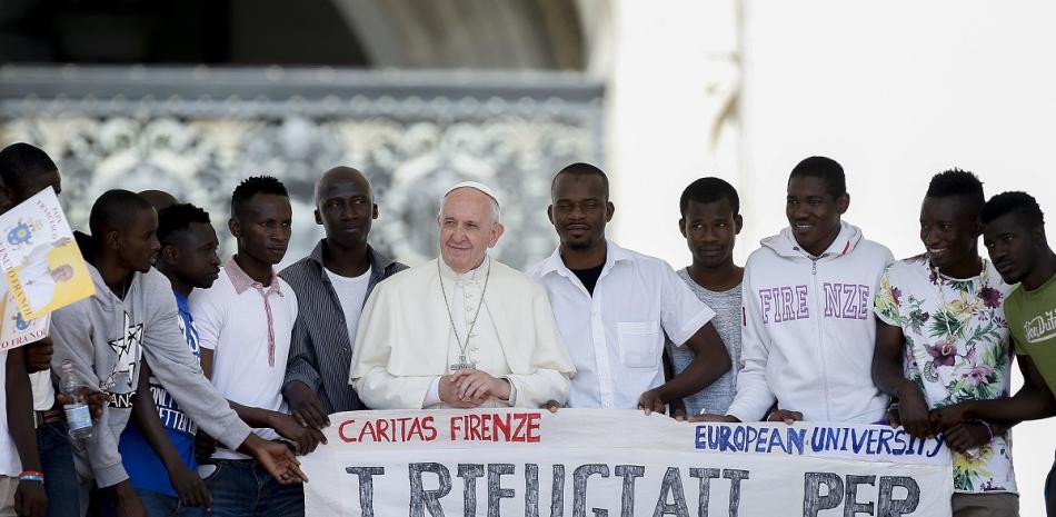 En esta imagen de archivo, el papa Francisco posa para una fotografía con un grupo de refugiados a los que invitó a las escaleras de la Basílica de San Pedro.