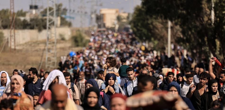 Familias palestinas que huyen de la ciudad de Gaza y otras partes del norte de Gaza hacia las zonas del sur, caminan por una carretera el 10 de noviembre de 2023 en medio de las batallas en curso entre Israel y el movimiento palestino Hamas.