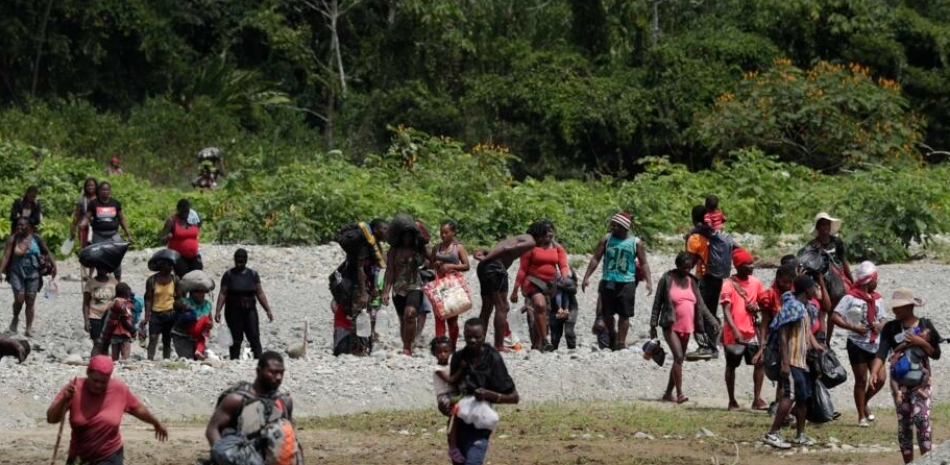 Migrantes cruzan el río Tuquesa después de un viaje a pie a través de la selva hacia Bajo Chiquito, provincia de Darién, Panamá, el miércoles 10 de febrero de 2021.