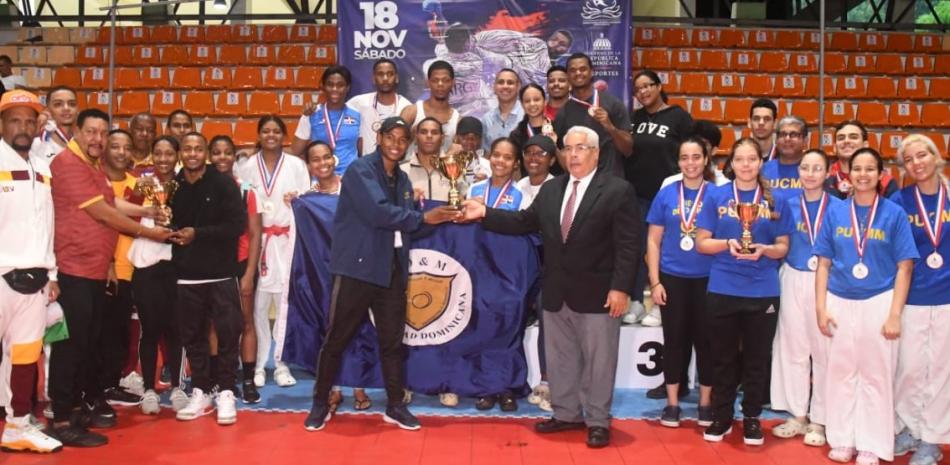José Luis Ramírez, presidente de la Federación Dominicana de Karate entrega la copa de campeón al equipo de la Universidad O&M.