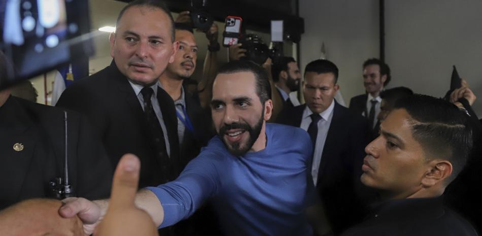 Seguidores del presidente de El Salvador, Nayib Bukele, lo saludan después de que acudiera al Tribunal Supremo Electoral a registrarse como candidato.