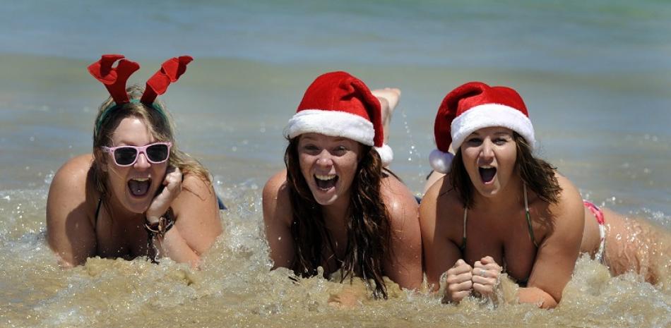 Turistas disfrutan en la playa Bondi de Sídney, Australia, donde miles de veraneantes toman el sol como de costumbre durante las Navidades en esa playa ubicada en el hemisferio sur. EFE/Mick Tsikas