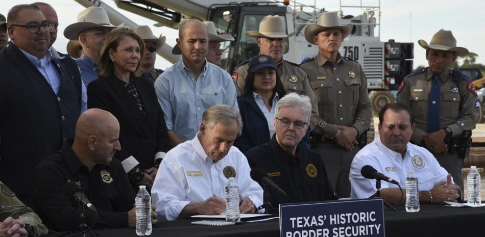 El gobernador de Texas, Greg Abbott, promulga tres iniciativas de ley el lunes 18 de diciembre de 2023, en un sitio ubicado frente al muro fronterizo, en Brownsville, Texas