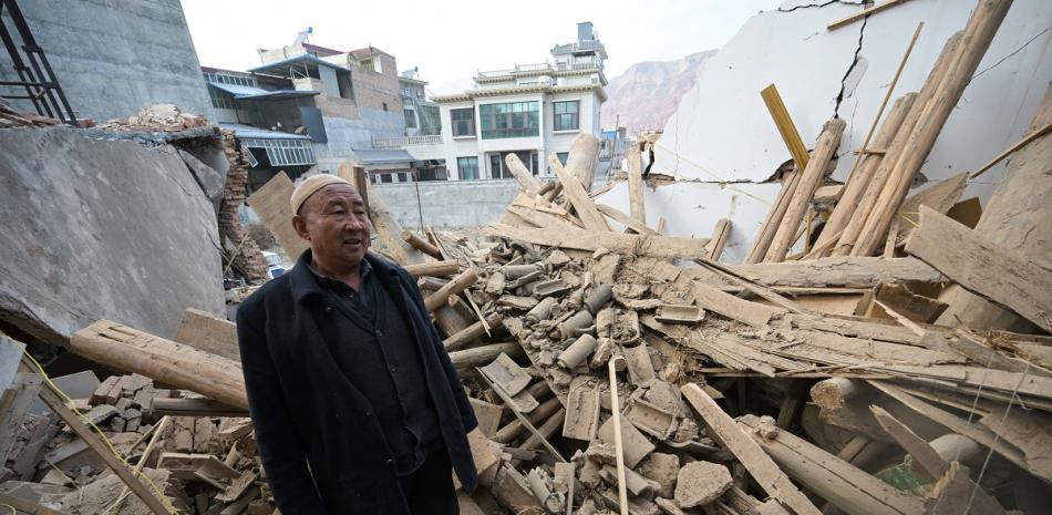 Un hombre inspecciona un edificio dañado después de un terremoto en Dahejia, en el condado de Jishishan, en la provincia de Gansu.