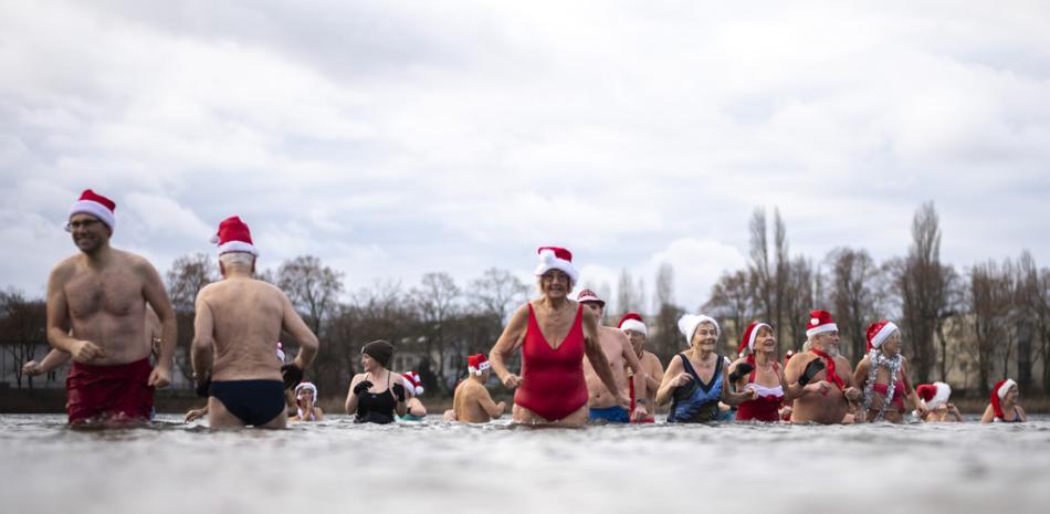 Nadadores de invierno participan en un tradicional evento de natación navideño en el lago Orankesee en Berlín, Alemania, el lunes 25 de diciembre de 2023.AP Photo/Markus Schreiber)