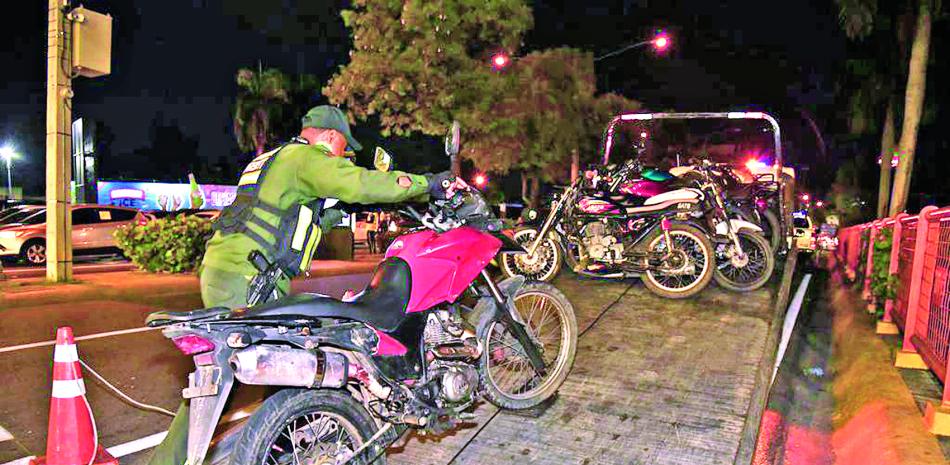 Agentes de la Digesett montan en una unidad varias motocicletas detenidas a conductores durante el operativo.