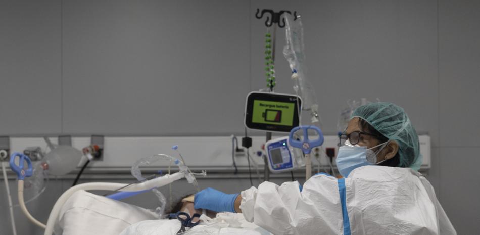 Un sanitario alrededor de un paciente ingresado en la UCI del Hospital Enfermera Isabel Zendal, a 13 de enero de 2022, en Madrid (España).