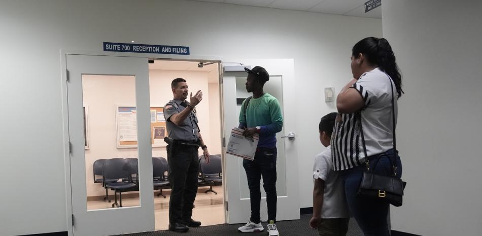 Un oficial ayuda a un grupo de personas en un tribunal de inmigración en Miami, el 10 de enero de 2024.