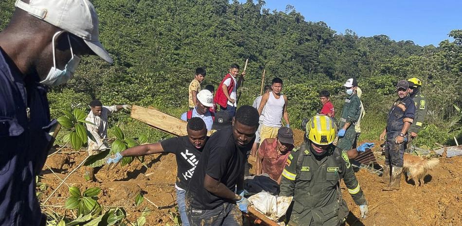 Socorristas hallan el cuerpo de una víctima fatal de un derrumbe vial que dejó decenas de muertos y heridos en el oeste de Colombia, el sábado pasado.