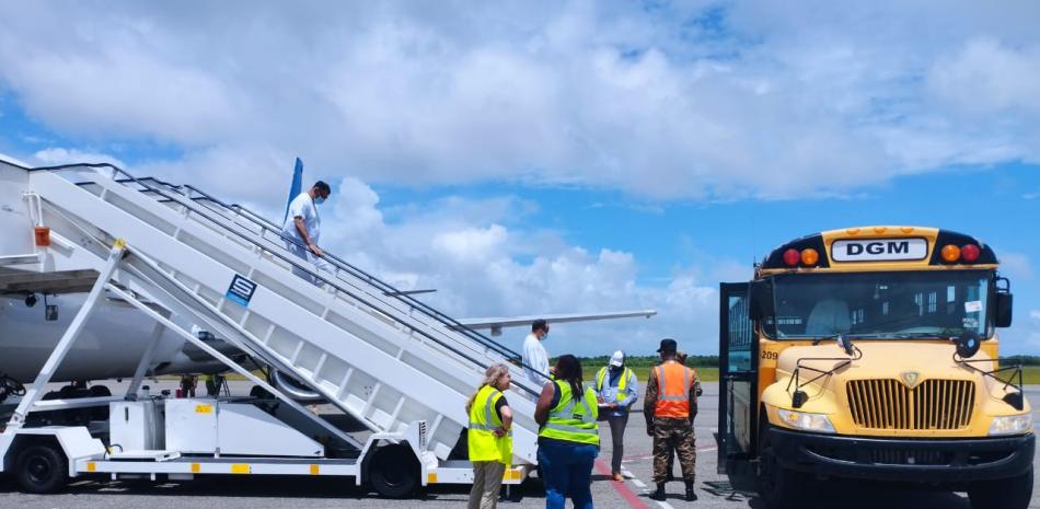 Dominicanos repatriados abordan vehículo que los llevará hasta Haina paradepuración.