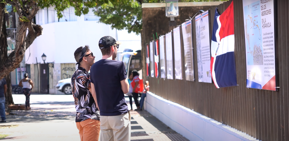 Dos turistas observan las ilustraciones en el parque Independencia.