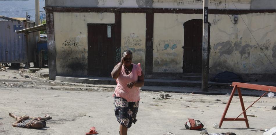 Una mujer pasa junto a los cuerpos de los reclusos afuera de la Penitenciaría Nacional en Puerto Príncipe, Haití, el domingo 3 de marzo de 2024.