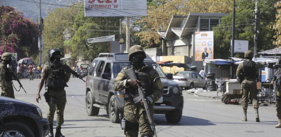 Elementos de la Unidad de Seguridad General del Palacio Nacional de Haití establece un perímetro para retomar el control de una de las tres delegaciones de policía que fueron tomadas por pandillas, en el centro de Puerto Príncipe, Haití, el sábado 9 de marzo de 2024.