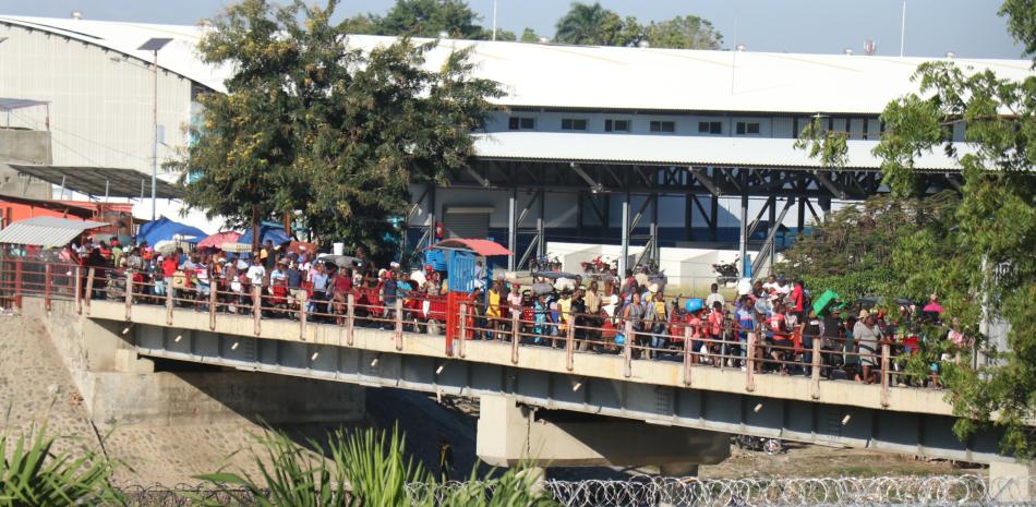 Cientos de haitianos cruzan el puente sobre el río Masacre que divide a Juana Méndez con Dajabón
