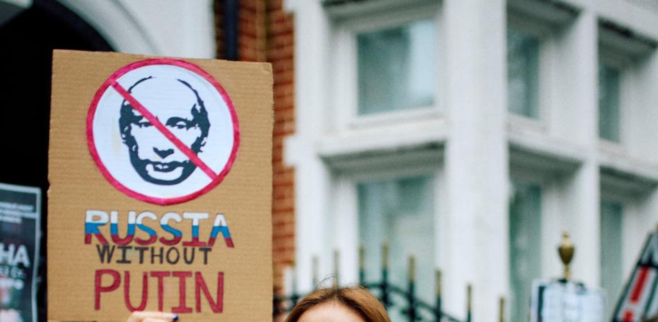 Un manifestante sostiene una pancarta durante una reunión frente a la embajada rusa, en Londres, el 17 de marzo de 2024, para protestar contra las elecciones presidenciales de Rusia.