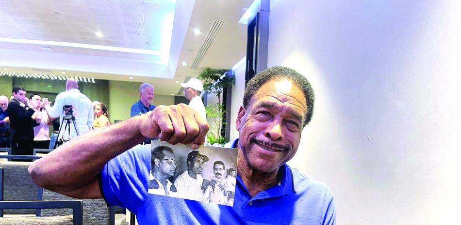 Dave Winfield muestra una foto de la primera ocasión que vino al país en 1984 como un miembro de los Yankees. En la gráfica junto a los periodistas Temo Metz y Gustavo Rodríguez.