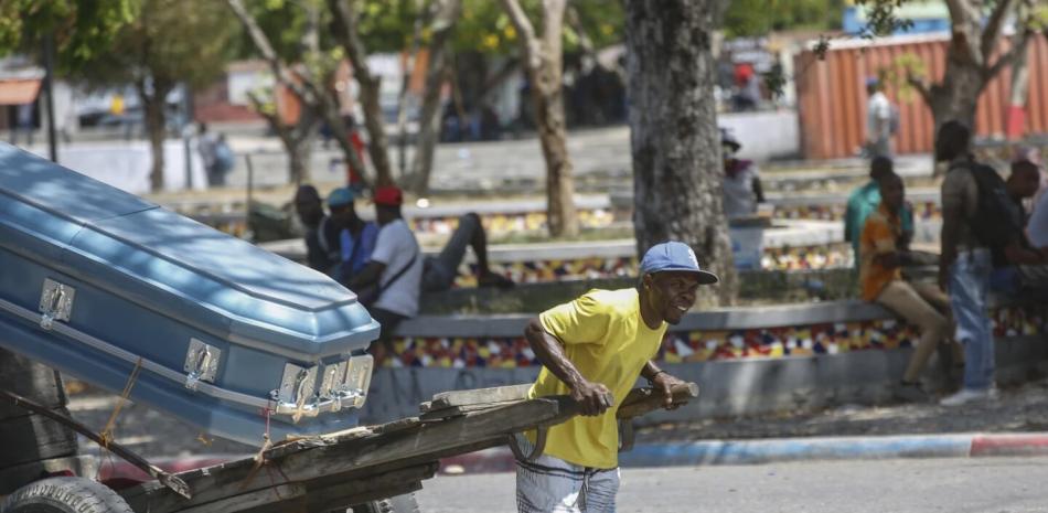 Un hombre transporta un ataúd en Puerto Príncipe.