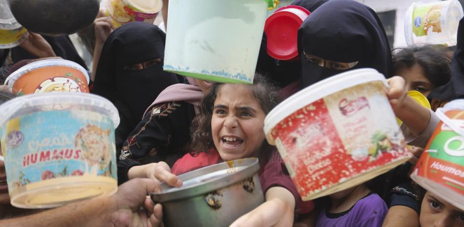 Palestinos hacen cola para recibir comida durante el bombardeo israelí en curso de la Franja de Gaza en Rafah el 13 de noviembre de 2023.