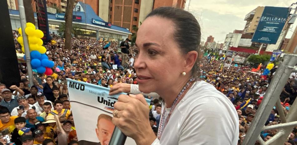 La líder opositora María Corina Machado sostiene una pancarta del candidato presidencial Edmundo González mientras habla a sus seguidores durante un mitin en Maracaibo, Venezuela
