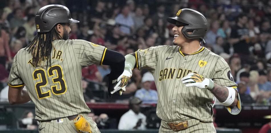 Fernando Tatis Jr.y Manny Machado se felicitan luego que el segundo conectara un vuelacercas en la victoria de los Padres sobre los D- Backs.