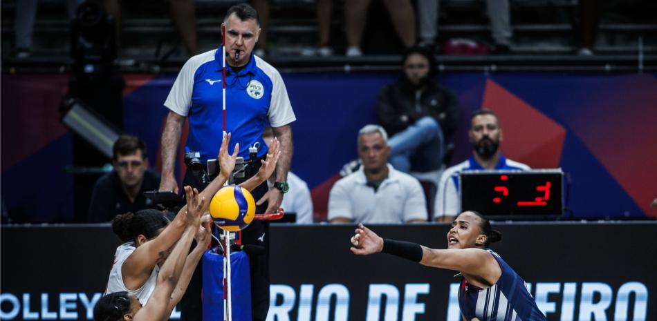 Gaila González trata de anotar un punto, pero recibe un bloqueo de un par de jugadoras de Canadá en el choque que las dominicanas sucumbieron.