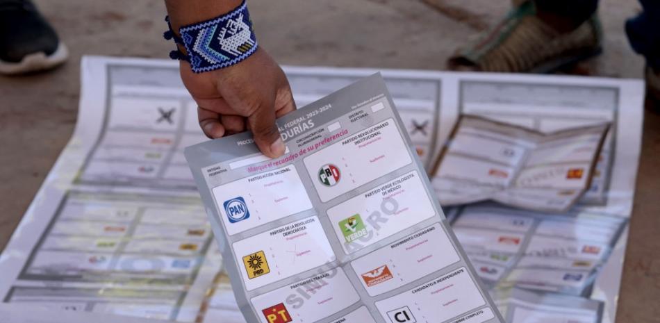 Un indígena wixárika sostiene una guía de votación en una escuela primaria durante un simulacro del día de las elecciones como parte de la capacitación impartida por funcionarios del Instituto Nacional Electoral (INE) antes de las próximas elecciones del 2 de junio en Tuxpan de Bolaños, estado de Jalisco. México, a 18 de mayo de 2024.