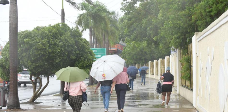 Personas caminando bajo la lluvia en el Distrito Nacional