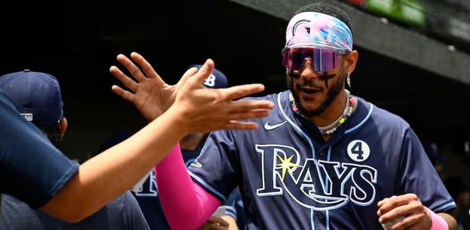 José Siri es felicitado por compañeros al arribar al dugout luego de dispara un doblete de dos vueltas en la victoria de los Rays.