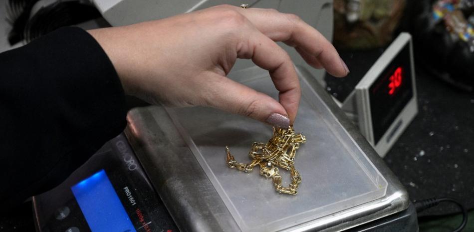 Un tasador pesa joyas de oro en un concesionario de oro en Buenos Aires  JUAN MABROMATA /