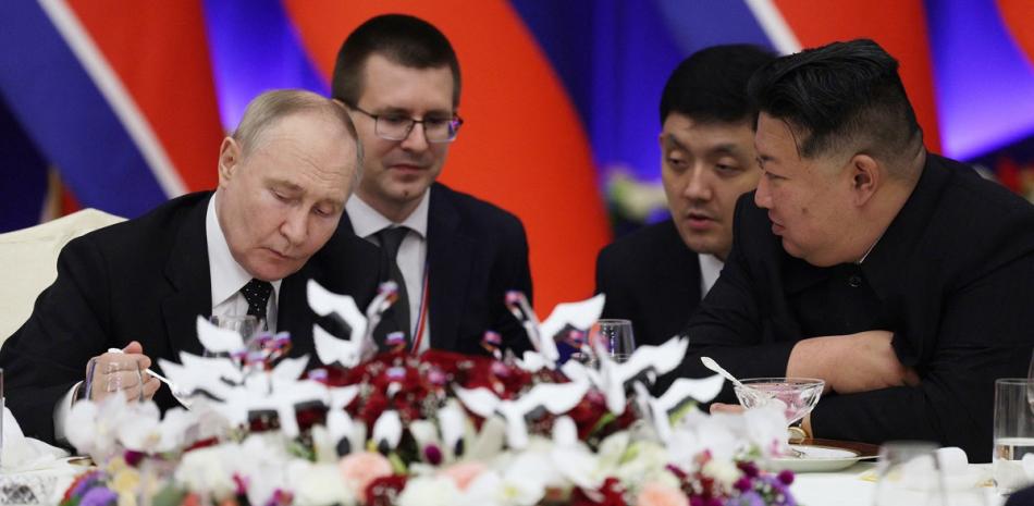 Vladimir Putin (izq.) y  Kim Jong Un (der.), almuerzan ayer en Pyongyang, junto a sus traductores.