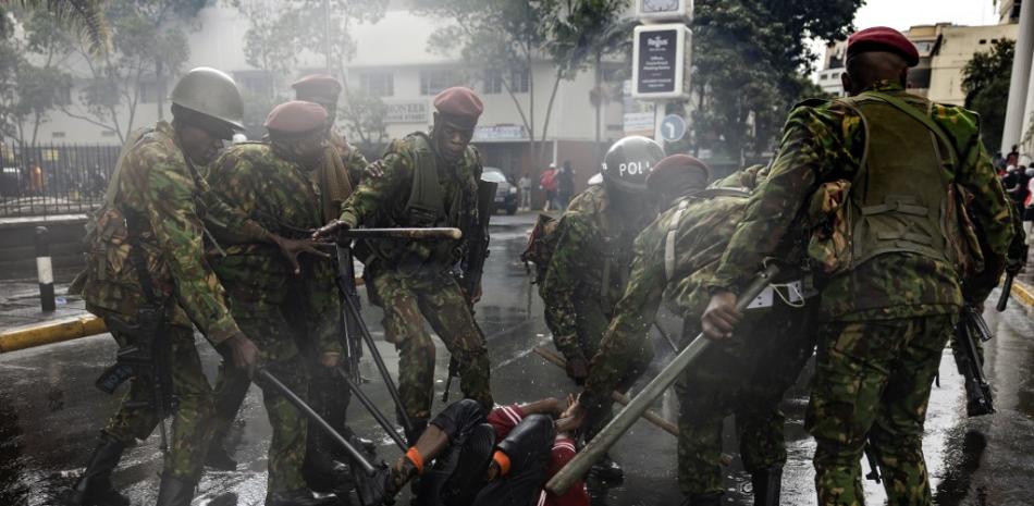 Agentes de policía de Kenia rodean a un manifestante durante una manifestación contra los aumentos de impuestos mientras los miembros del Parlamento votan el Proyecto de Ley de Finanzas 2024 en el centro de Nairoibi, el 20 de junio de 2024.