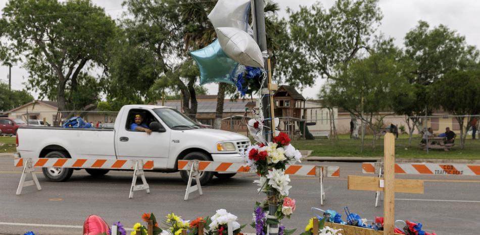 El pasajero de una camioneta observa un homenaje improvisado en el lugar donde ocho migrantes murieron arrollados y otros resultaron heridos un día antes, en una parada de autobús, el lunes 8 de mayo de 2023, en Brownsville, Texas