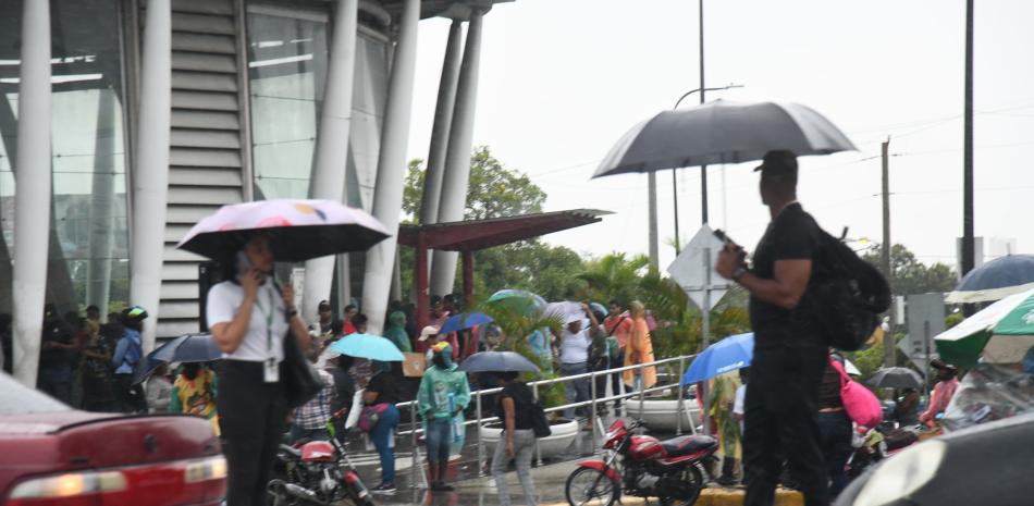 Personas se dirigen al metro bajo lluvia