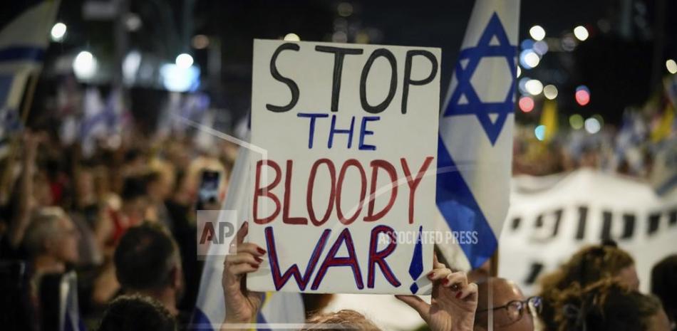 Una manifestante sostiene un cartel durante una protesta que marca nueve meses desde el inicio de la guerra y pide la liberación de los rehenes retenidos en la Franja de Gaza por el grupo armado Hamás, en Tel Aviv, el domingo pasado."Detengan la maldita guerra", en el letrero.