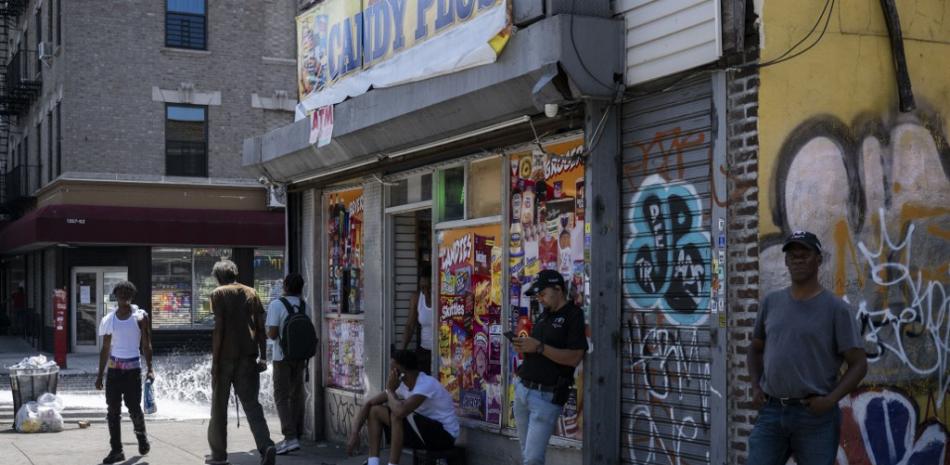 Un grupo de personas frente a una bodega durante una ola de calor veraniega en el barrio neoyorquino del Bronx el 11 de julio de 2024